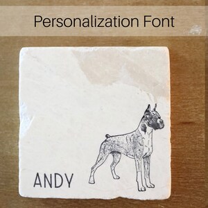 May include: A square, off-white stone coaster with a black illustration of a Boxer dog. The name "ANDY" is printed in black below the dog. The text "Personalization Font" is at the top.
