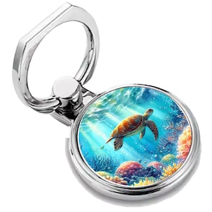 May include: A silver phone ring holder with a round, colorful image of a sea turtle swimming in a blue ocean with coral reefs.