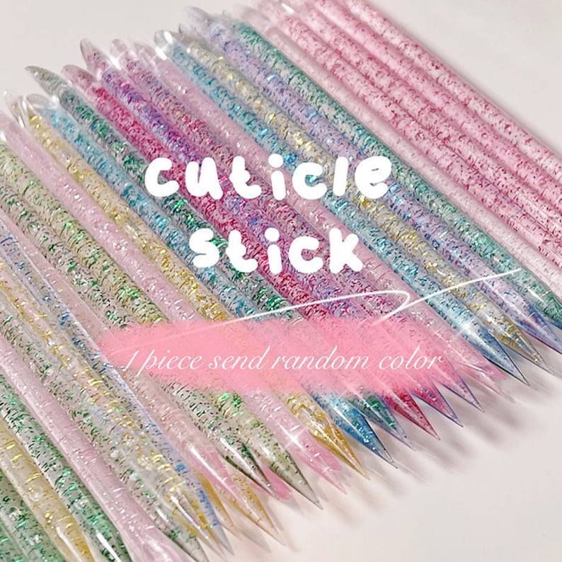 Puede incluir: Primer plano de un mont&oacute;n de palitos para cut&iacute;culas transparentes con purpurina en su interior. Los palitos son de varios colores, incluyendo rosa, azul, verde y dorado. El texto "cuticle stick" est&aacute; escrito en letras blancas sobre un fondo rosa. El texto "1 piece send random color" est&aacute; escrito en letras blancas sobre un fondo rosa.