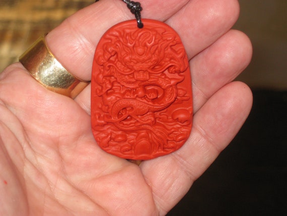 Hand carved red organic cinnabar Dragon pendant.