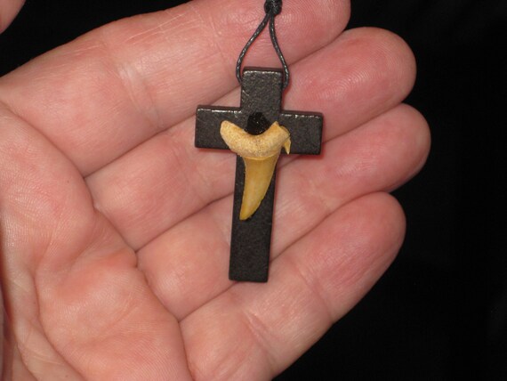 Hand carved wood cross pendant with fossilized shark tooth.