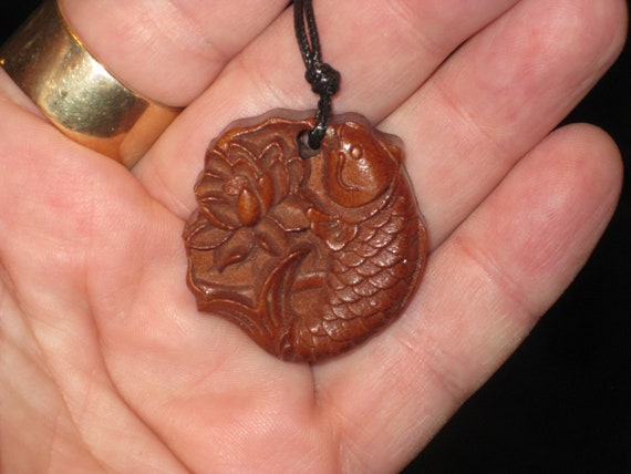 Hand carved Rosewood fish and lily pad pendant necklace.