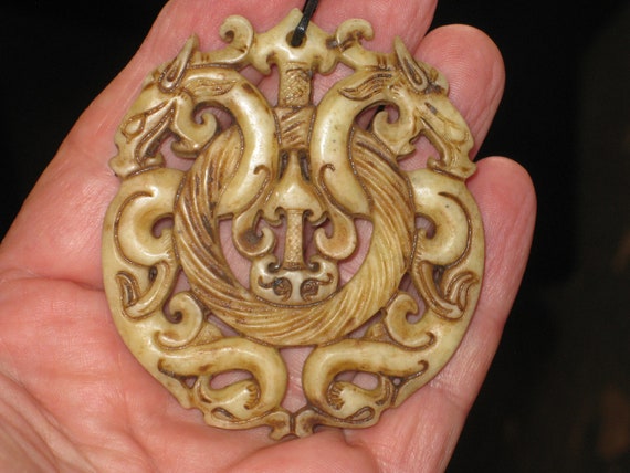 All natural jade hand carved two sided dragon pendant, with adjustable necklace.