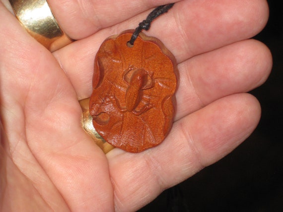 Hand carved Rosewood frog on lily pad pendant necklace.