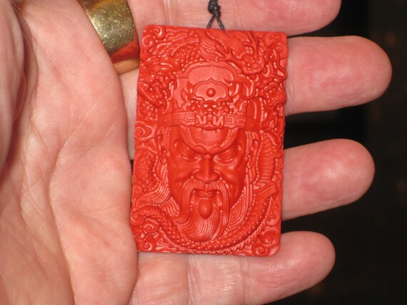 Hand carved red organic cinnabar warrior pendant.