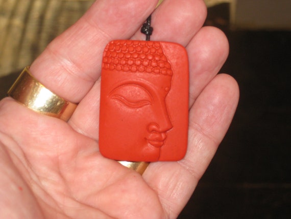 Hand carved red organic cinnabar Buddha pendant.