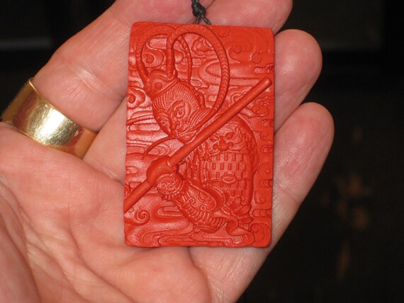 Hand carved red organic cinnabar warrior pendant.