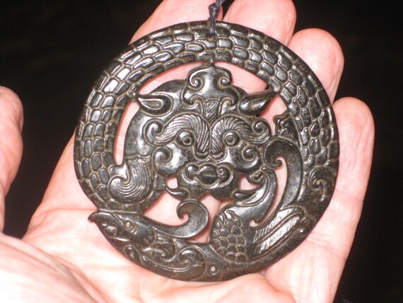 All natural hand carved two sided jade dragon and warrior mask pendant, with adjustable necklace.