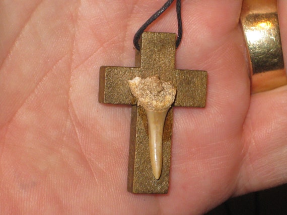 Hand carved wood cross pendant with fossilized shark tooth.