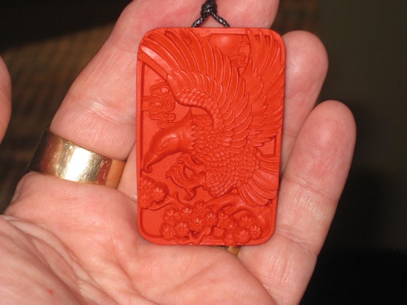 Hand carved red organic cinnabar eagle pendant.
