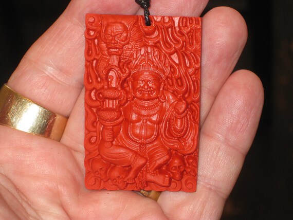 Hand carved red organic cinnabar pendant.