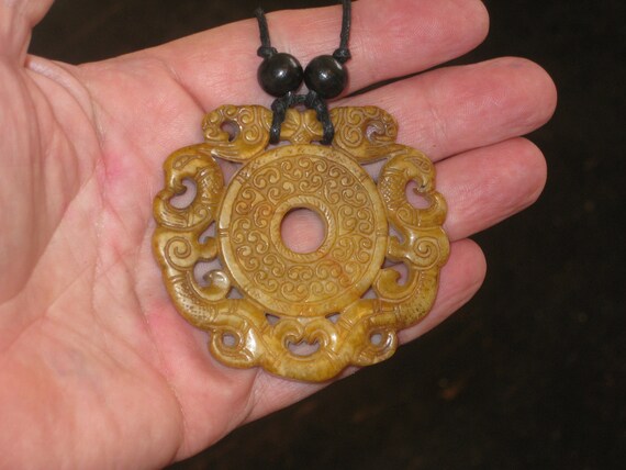 All natural hand carved two sided Jade pendant, with adjustable necklace.