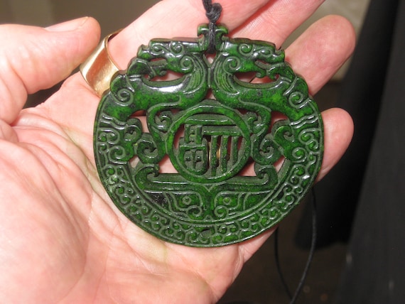 All natural jade hand carved two sided dragon pendant, with adjustable necklace.
