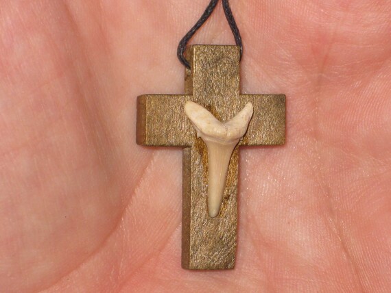 Hand carved wood cross pendant with fossilized shark tooth.