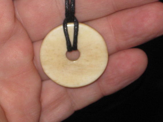 Buffalo bone hand carved disc pendant.