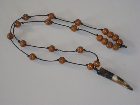 Hand carved buffalo bone pendant and wood beads from Africa.