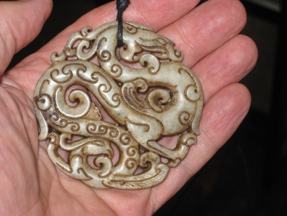 All natural jade hand carved two sided dragon pendant, with adjustable necklace.