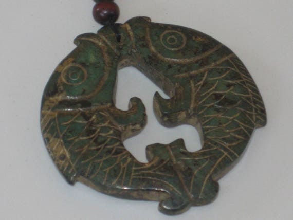 All natural hand carved two sided Jade fish amulate, with adjustable necklace.
