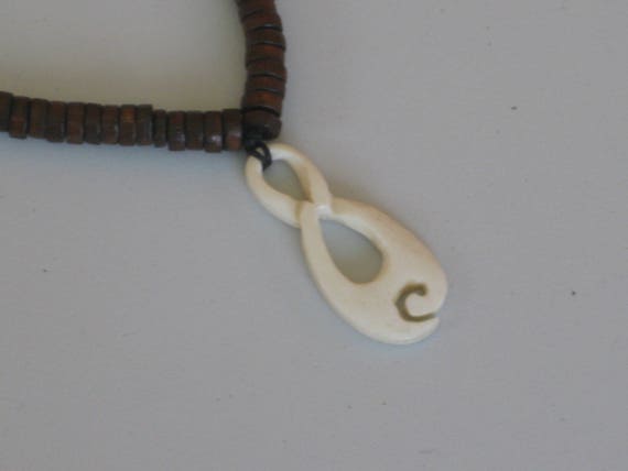 Hand carved bone pendant with heishi beads, 24" long.