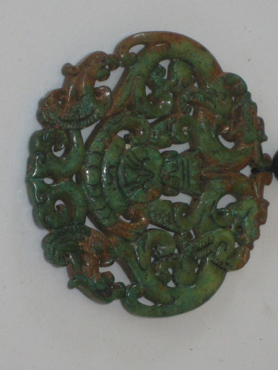 All natural hand carved two sided Jade dragon pendant with man praying.