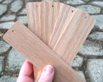 May include: A set of six unfinished wooden bookmarks with rounded edges and holes punched at the top. The bookmarks are arranged in a fan shape and are ready for personalization.