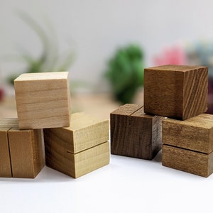 May include: Six wooden blocks, some stained brown and some natural wood, stacked in a pyramid shape. The blocks have a groove cut into the top, making them ideal for displaying small items.