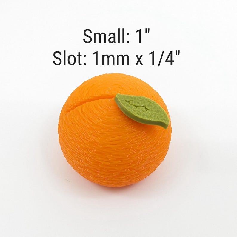 May include: An orange-colored, spherical object with a textured surface and a green leaf. The object has a slot cut into it. Text on the image reads "Small: 1"" and "Slot: 1mm x 1/4""