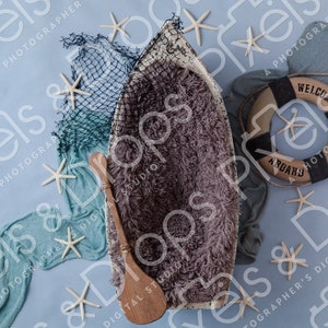 May include: A wooden boat-shaped newborn photo prop with a fuzzy gray interior, surrounded by blue and white fabric, starfish, and a life preserver with the text "Welcome Aboard".
