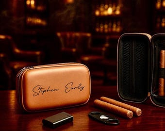 Op de afbeelding: Een bruine leren sigarenkist met de naam "Stephen Early" gegraveerd op de voorkant. De kist is open en er zitten drie sigaren in. Er is ook een sigarencutter op de tafel.