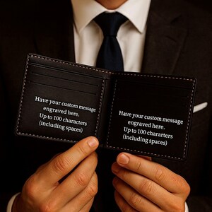 Man in a suit holding open a black leather bifold wallet, showing two interior panels with sample engraving text that reads “Have your custom message engraved here. Up to 100 characters (including spaces).” Wallet features multiple card slots and contrast stitching, presented in a classy, gift-ready style.