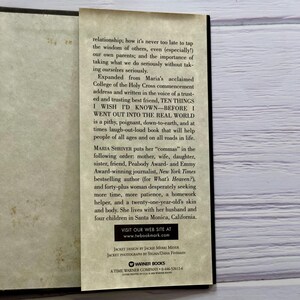 May include: Open book with a bookmark. The bookmark features text from the book "TEN THINGS I WISH I'D KNOWN - BEFORE I WENT OUT INTO THE REAL WORLD" by Maria Shriver. The book's cover is not visible.