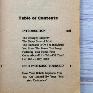 May include: A book's table of contents page, with the title "Table of Contents" in bold black font. The page lists chapter titles including "The Unhappy Majority" and "Dehypnotizing Yourself."