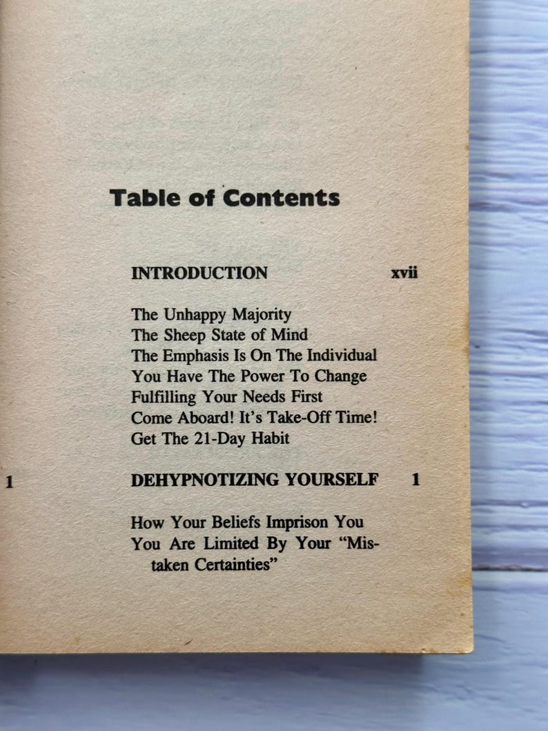 May include: A book's table of contents page, with the title "Table of Contents" in bold black font. The page lists chapter titles including "The Unhappy Majority" and "Dehypnotizing Yourself."