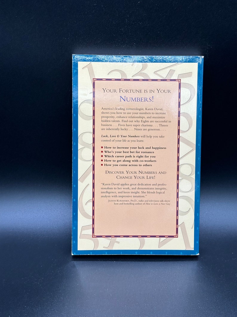 May include: A blue and white book cover with the title "Your Fortune is in Your Numbers!" by Karen David. The cover features a colourful design of numbers and a quote about the author's work.