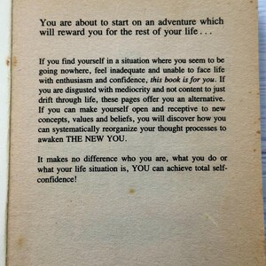 May include: Aged book page with text about self-improvement. The text reads, "You are about to start on an adventure which will reward you for the rest of your life..." The page has a light brown colour.