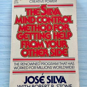 May include: A vintage paperback book titled "The Silva Mind Control Method for Getting Help from Your Other Side." The cover features red and gold lettering on a cream background, with the author's name, José Silva, at the bottom.