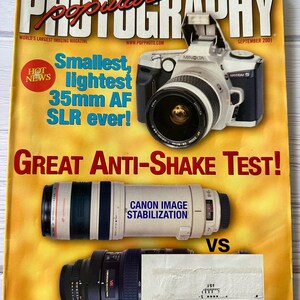 May include: A magazine cover for Popular Photography, issue 51, September 2001. The cover features a headline that reads "Smallest, lightest 35mm AF SLR ever!" and a sub-headline that reads "Great Anti-Shake Test!" The cover also features a photo of a Minolta Maxxum 5 camera and two camera lenses, one with Canon Image Stabilization and the other with VR.