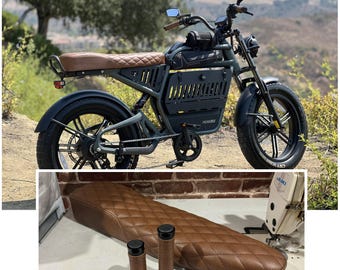 May include: An electric bicycle with a dark green frame, black tires, and a brown diamond-stitched seat. The image also shows a matching seat and handlebar grips. The text at the bottom reads "(MATCHING GRIPS SOLD SAPERATELY)".
