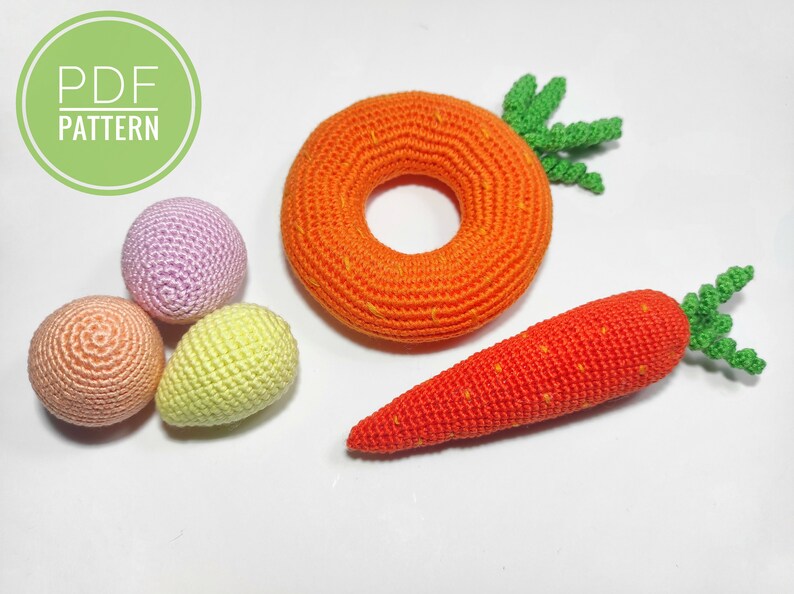 Puede incluir: Zanahoria, anillo y tres huevos tejidos a crochet en varios colores pastel.  PDF PATTERN est&aacute; escrito en un c&iacute;rculo verde.
