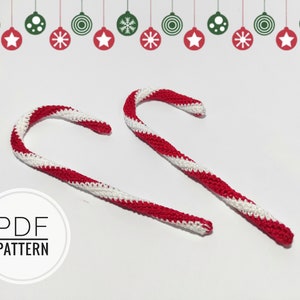 May include: Two crocheted candy canes with red and white stripes. The candy canes are curved and have a textured appearance. The image also includes a decorative border of Christmas ornaments and the text "PDF PATTERN".