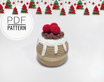 May include: Crochet pattern for a Christmas pudding ornament. The ornament is brown and beige with white icing and red cherries on top. The pattern is available as a PDF download.