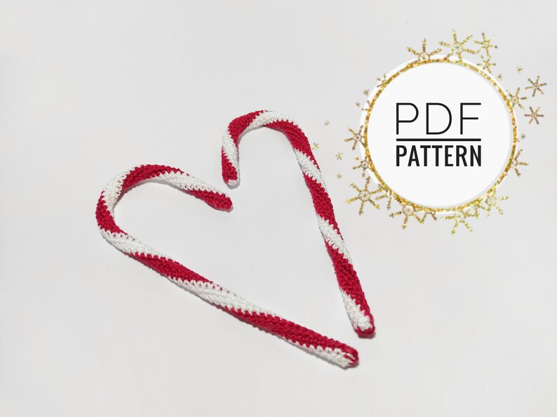 May include: Two handmade crochet candy canes with red and white stripes, arranged on a white surface. The image includes a circular graphic with the text "PDF PATTERN".