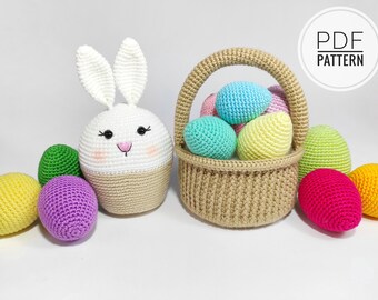 May include: A crocheted Easter bunny with a basket full of colorful crocheted eggs. The bunny is white with a brown base and black eyes. The basket is brown and the eggs are in various colors, including pink, blue, yellow, green, and red.