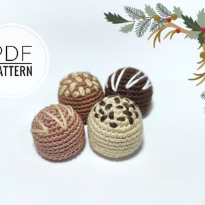 May include: Four crocheted chocolate truffles in different colors and designs. The truffles are brown, beige, and pink. The truffles have different designs, including white stripes, brown sprinkles, and brown swirls.