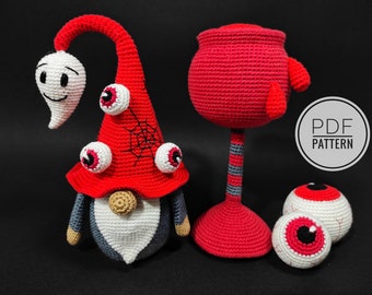 May include: Crochet amigurumi pattern for a Halloween gnome with a red hat, white ghost, and googly eyes. The pattern also includes a red cauldron and two eyeball ornaments. PDF PATTERN.
