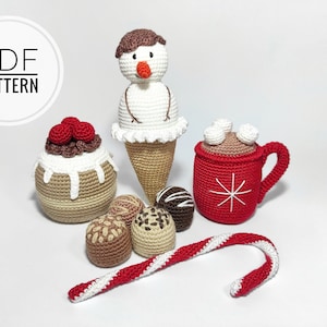 May include: Crocheted winter-themed toys including a snowman ice cream cone, a chocolate cake, a mug of hot chocolate with marshmallows, chocolate candies, and a candy cane.