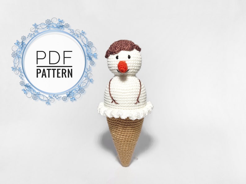 May include: Crocheted snowman ice cream cone amigurumi toy pattern. The snowman has a brown hair, white body, and a red nose. The ice cream cone is brown and white.