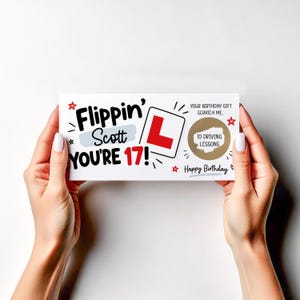 May include: A rectangular birthday card with white background featuring the black text Flippin' Scott YOU'RE 17!, a red L-plate symbol, and a gold circular scratch-off area with the text 10 DRIVING LESSONS. Red stars and black accents decorate the card.