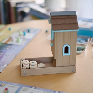Side view of a Wingspan board game dice tower
