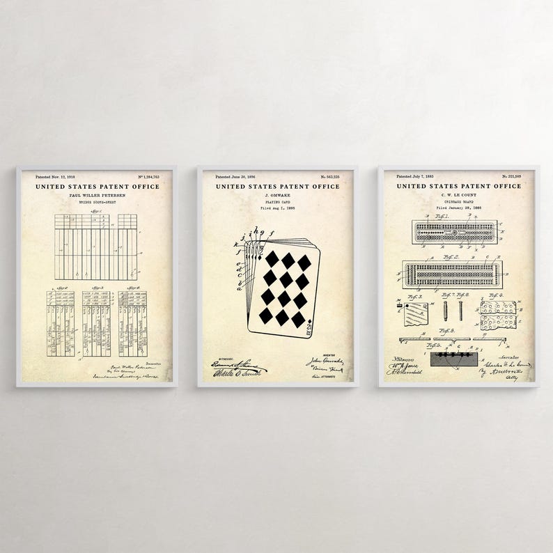 May include: Three framed vintage patent prints. The prints feature detailed technical drawings of playing card designs and related mechanisms. The frames are white, and the prints have a sepia-toned background.